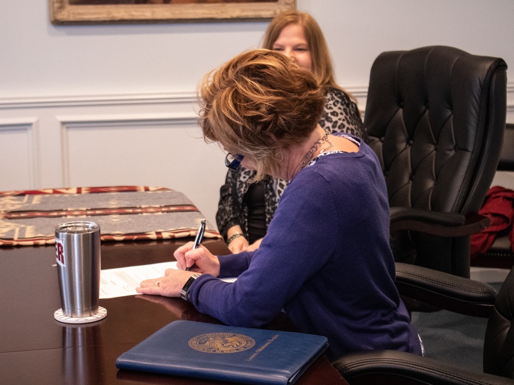 Robin Phillips, Superintendent of the Osage Agency, signs documents for bringing the Osage-owned Tulsa Airpark into Federal Trust